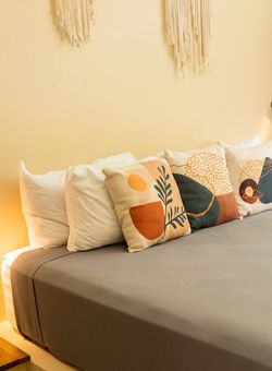 Área exterior para yoga con esterilla naranja, pesas y plantas tropicales