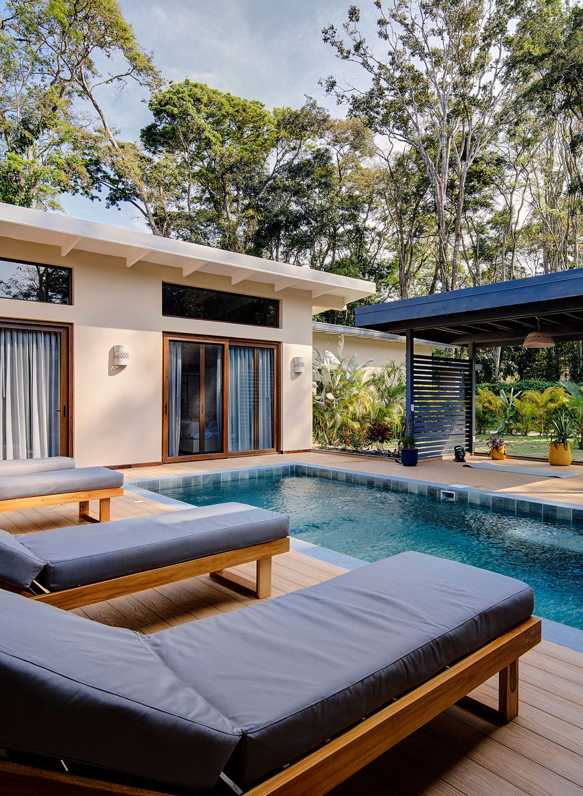Piscina rodeada de vegetación con zona de relajación y espacio para yoga, meditación u otras actividades